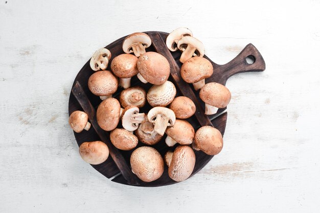 Mushrooms on a white wooden background Champignons Top view Free copy space