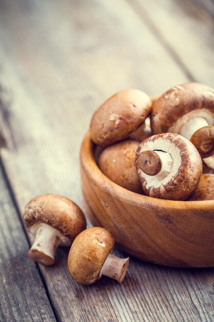 Mushrooms in wooden bowl on table Selective focus