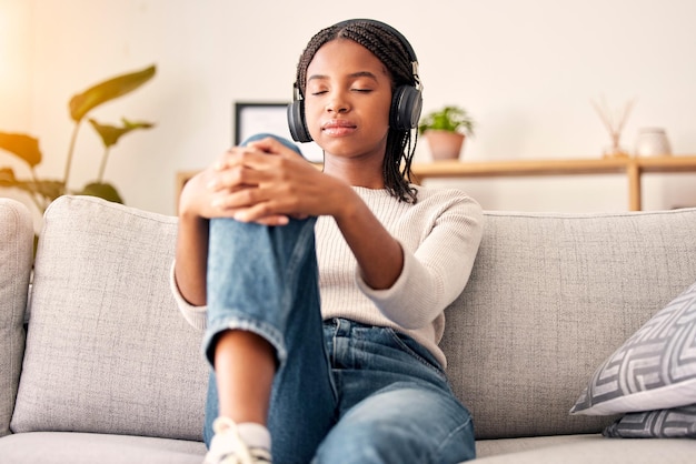 Music headphones peace and relax girl listening to wellness podcast for calm mindset mindfulness or audio meditation Easy meditating living room sofa or gen z black woman streaming zen radio song