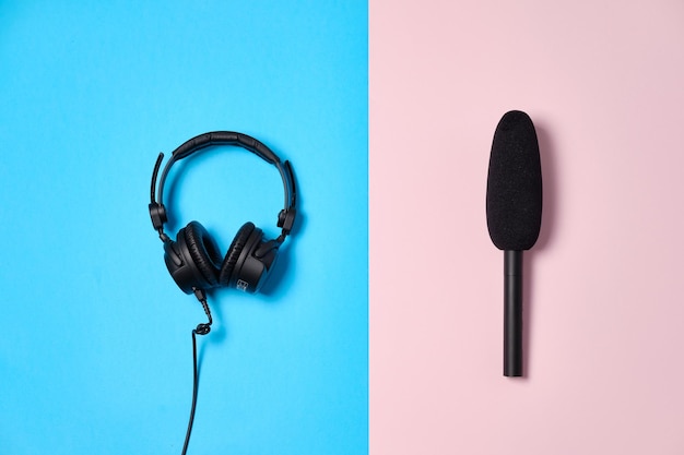 Music or podcast background with headphones and microphoneon blue table flat lay Top view flat lay