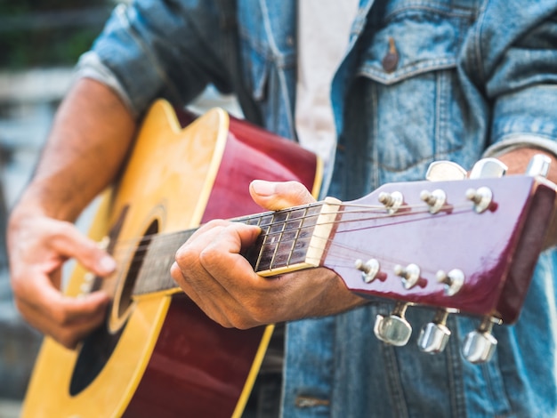 Musician playing acoustic guitar on blur background