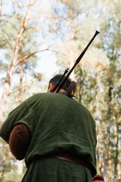 A musician playing the bagpipes at an outdoor music folk festival Rear view selective focus