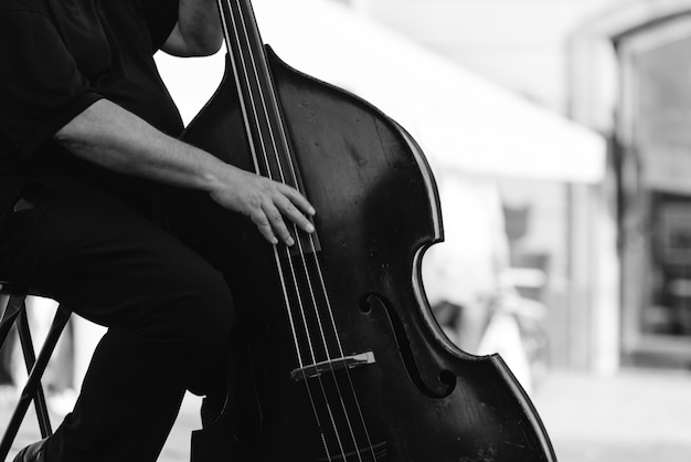 Musician playing double bass at the street. Musical Instrument Concept.