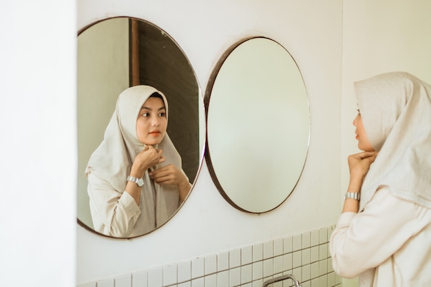 Muslim asian woman fixing her scarf