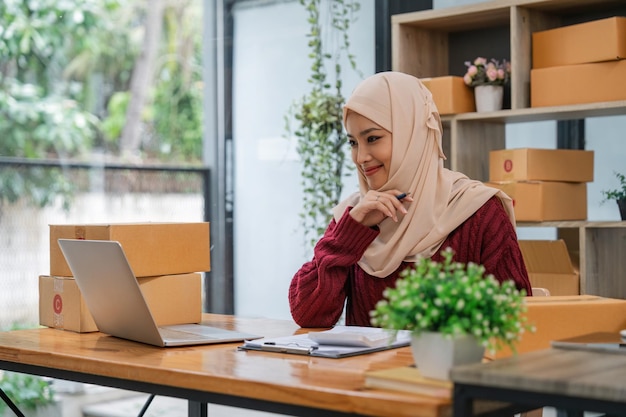 Muslim beautiful woman in hijab working online sales Checking for customer orders in office