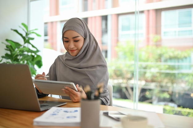 Muslim businesswoman or muslim female financial consultant working in her office