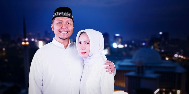 Muslim couple standing with night city background