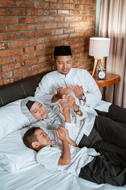 Muslim family pray on the bed