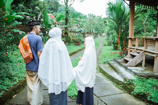 Muslim family with kid walking together and hold hand