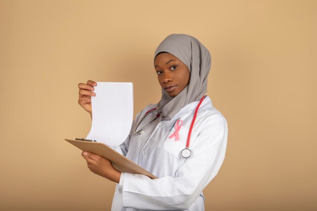 Muslim female doctor holding document