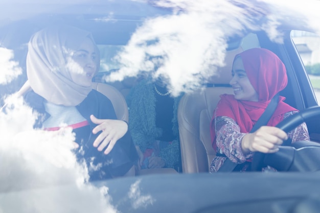 Muslim female friends enjoying road trip traveling at vacation in the car high quality photo