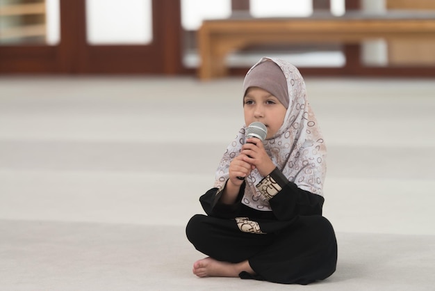 Muslim Girl In Headscarf Is Holding Microphone