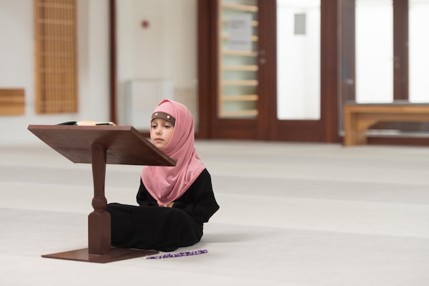 Muslim Girl In Headscarf Is Reading The Quran