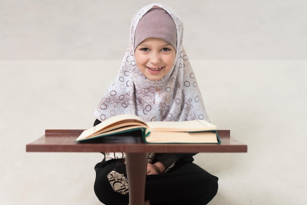 Muslim Girl In Headscarf Is Reading The Quran