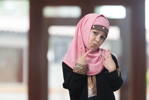 Muslim Girl Praying At Mosque Showing Peace Sign