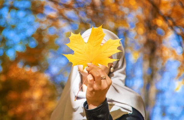 Muslim girl with autumn leaves Selective focus