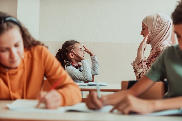 Muslim hijab the teacher plays and hugs the little girl at school Selective focus High quality photo