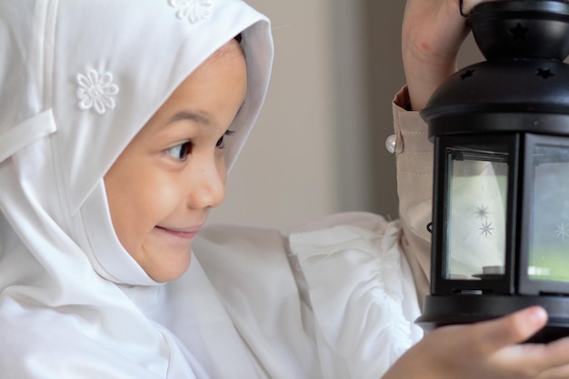 Muslim kid preparing lantern for ramadan holy monthAsian Muslim kid in traditional suit happy