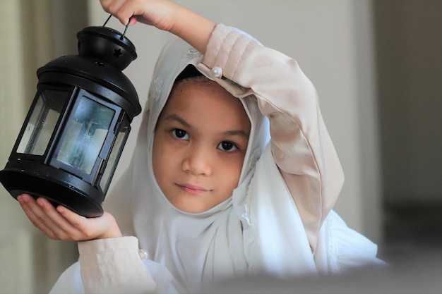 Muslim kid preparing lantern for ramadan holy monthAsian Muslim kid in traditional suit happy