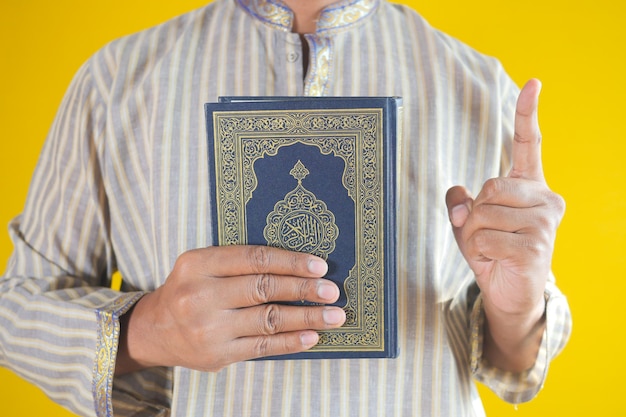 Muslim man hand holding Holy book Quran with copy space