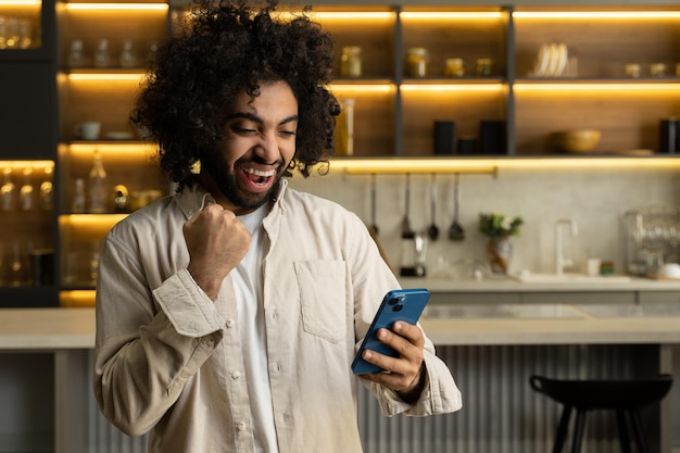 Muslim man plays game and wins in smartphone in kitchen