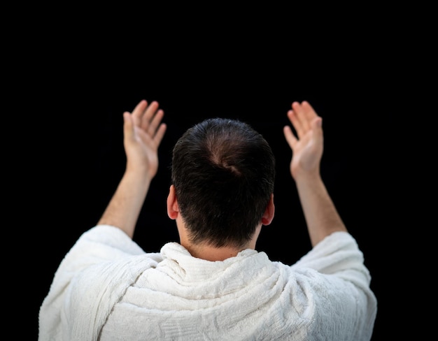 Muslim man standing and praying in the front of Kaaba in Mecca, KSA