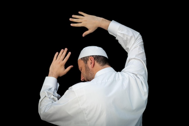 Muslim man standing and praying in the front of Kaaba in Mecca, KSA