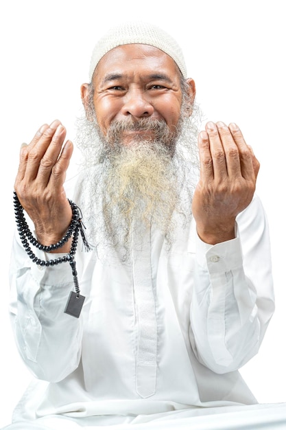 Muslim man with a beard wearing a white cap praying with prayer beads on his hands