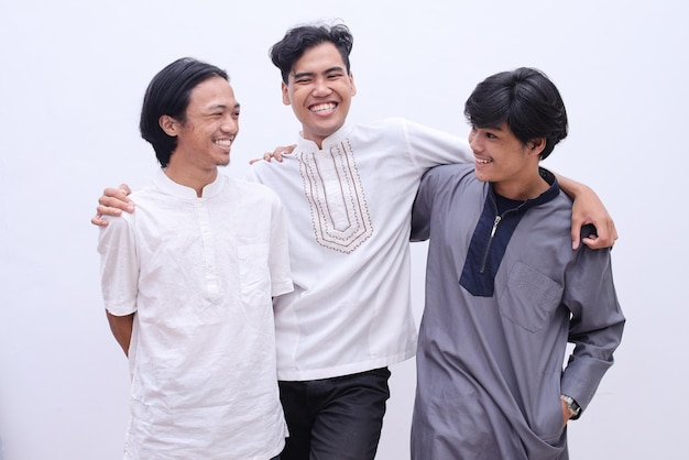 Muslim men in islamic wear enjoying their time during eid moment, isolated over white background.