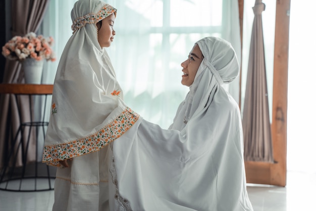 Muslim mother and child with scarf to pray