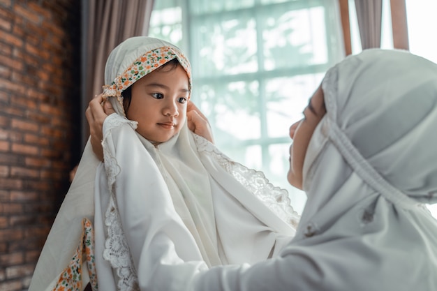 Muslim mother and child with scarf to pray