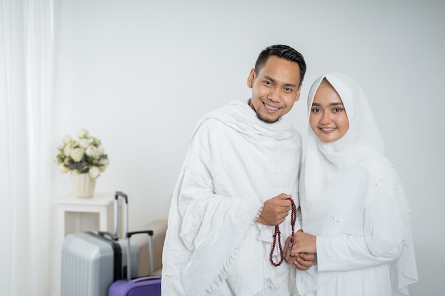 Muslim pilgrims wife and husband in white traditional clothes