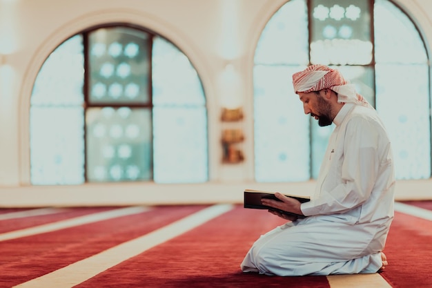 A Muslim reads the holy Islamic book Quraqn in a modern grand mosque during the Muslim holy month of Ranazan.