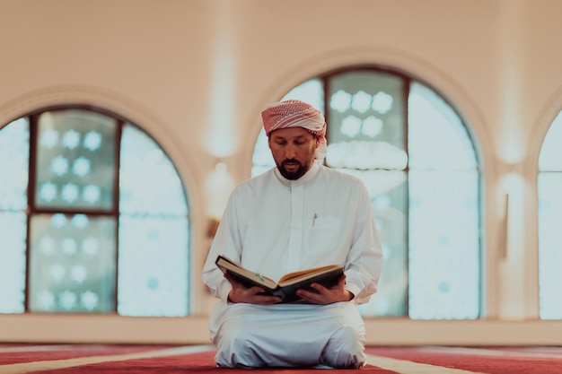 A Muslim reads the holy Islamic book Quraqn in a modern grand mosque during the Muslim holy month of Ranazan.