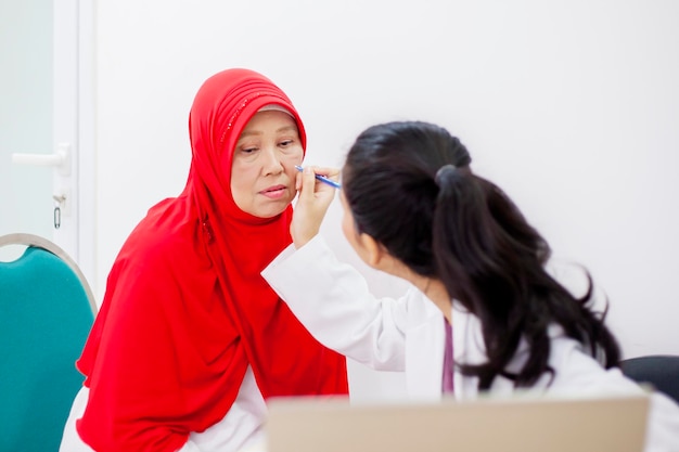 Muslim senior woman get make up done by a makeup artist