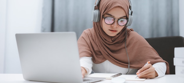 Muslim student using a laptop for distance learning