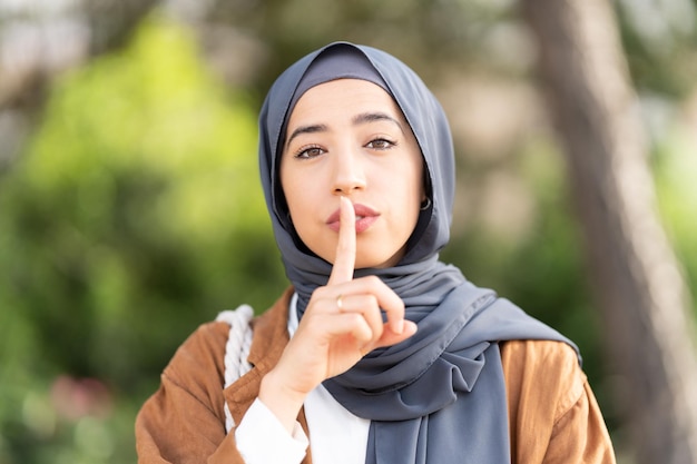 Muslim woman asking for silence outdoors Close up