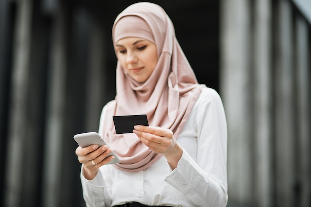 Muslim woman doing shopping with credit card and mobile