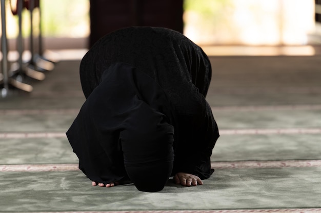 Muslim Woman in Hijab Praying on Mat