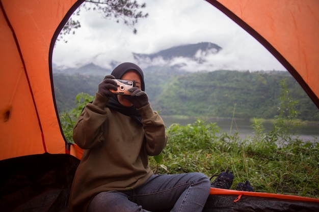 A muslim woman photographing in tent