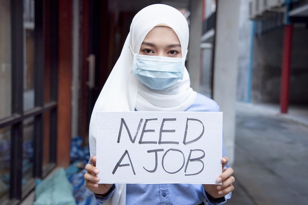 Muslim woman wearing face mask having no money due to job cut employment disruption after COVID19 pandemic led economic recession