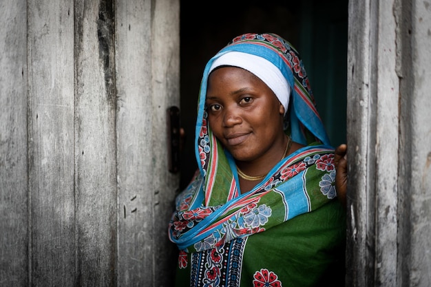 Muslim woman with hijab standing at the door of her house