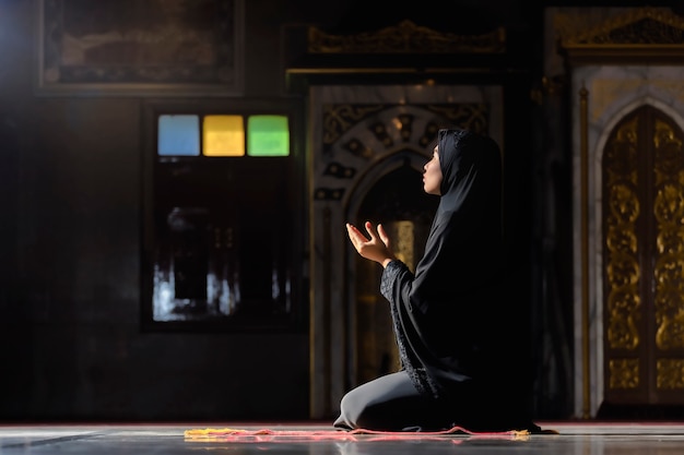 Muslim women wearing black shirts Doing prayer According to the principles of Islam.
