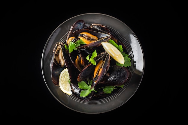 Mussels in wine with parsley and lemon. Seafood.