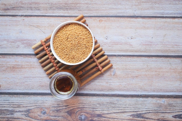 Mustard oil and raw seed in jar on table