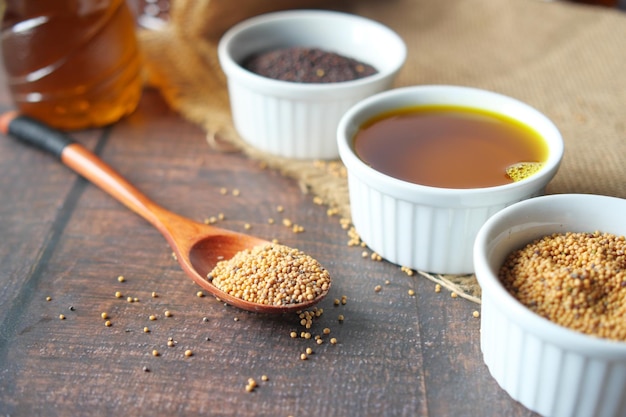 Mustard oil seeds on a spoon on table