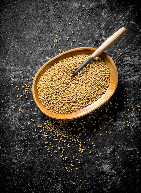 Photo mustard in a wooden plate with a spoon