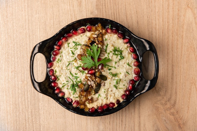 Mutabbal or mutabal granished with pomegranate seeds served in dish isolated on table top view of arabian food