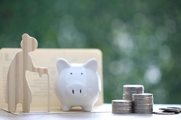 Mutual fundSenior with stack of coins money and piggy bank on natural green background Save money for prepare in future and pension retirement concept