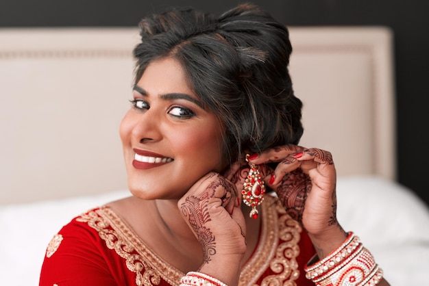 My bridal look wouldnt be complete without these Cropped portrait of a beautiful young bride putting on her earrings in preparation for her wedding